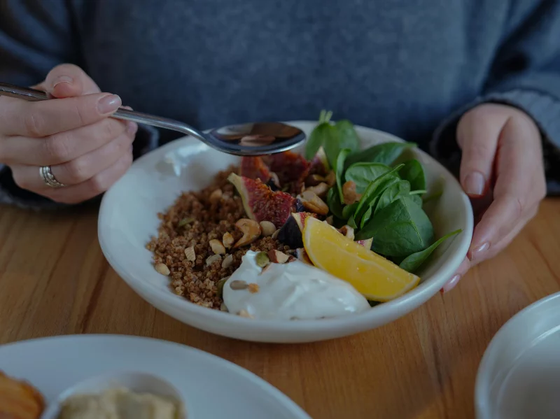 A vibrant brunch bowl with fruit, greens, and nuts for a nutritious meal.