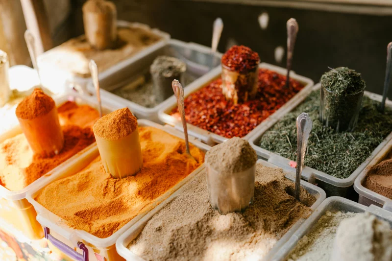 Vibrant selection of spices in containers at a Georgian market, showcasing diverse flavors.