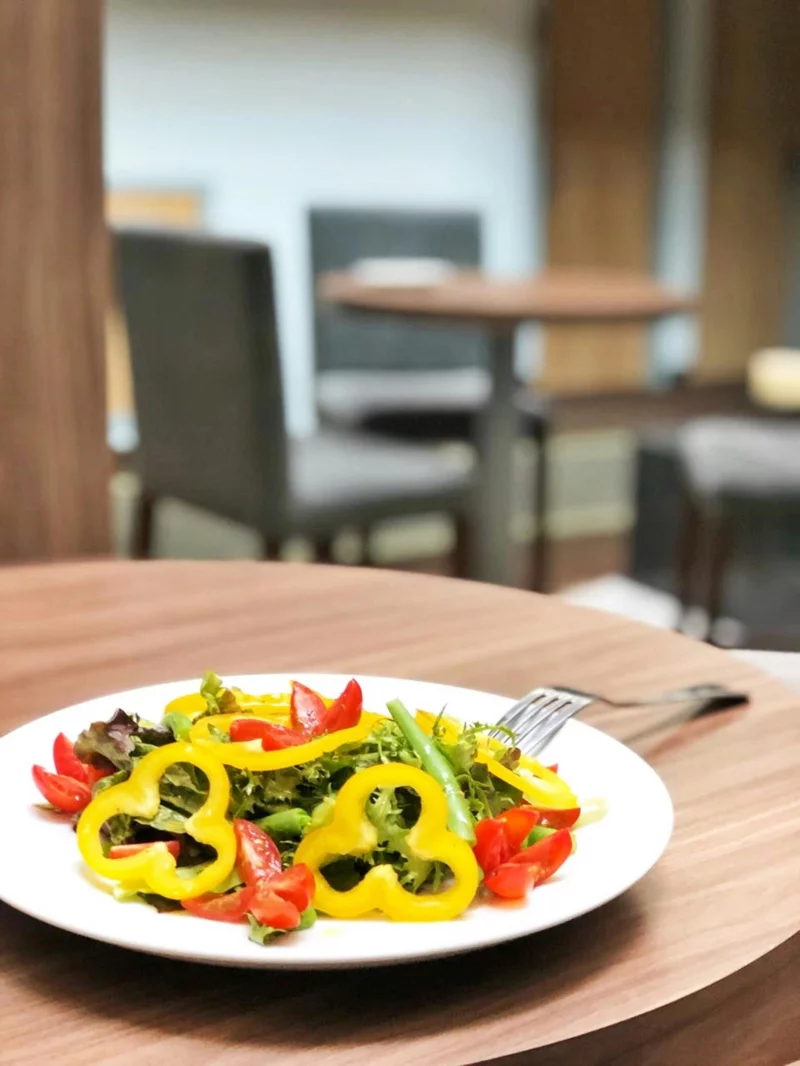 A vibrant mixed salad with colorful vegetables served on a dining table indoors.