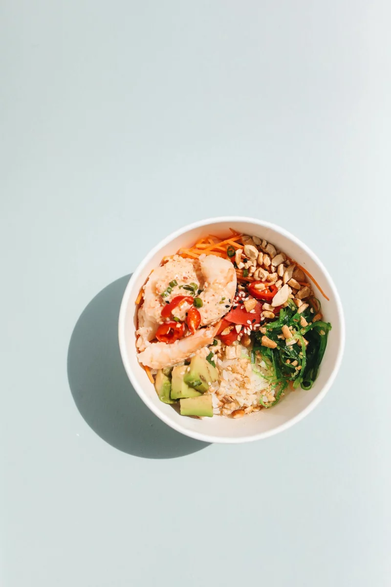 Delicious shrimp poke bowl with fresh ingredients like avocado and vegetables.