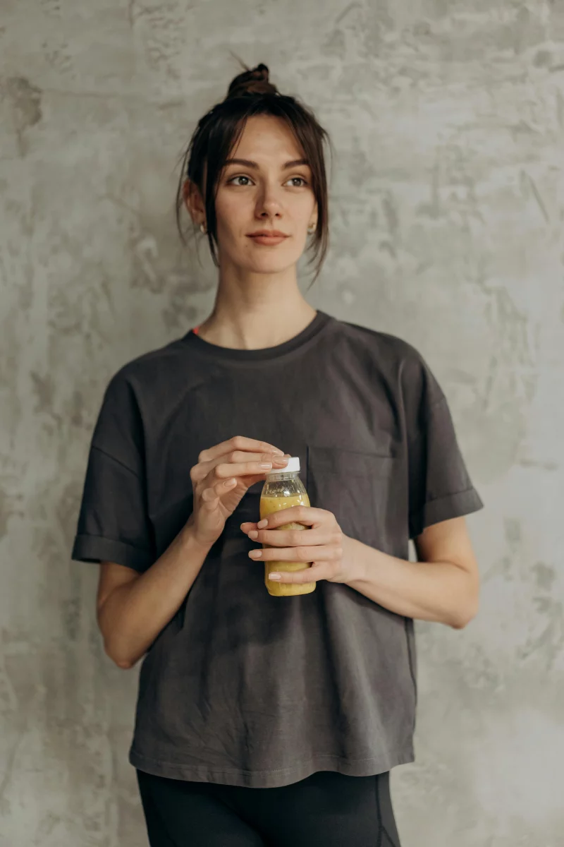 Young woman enjoying a refreshing nutritious drink indoors.