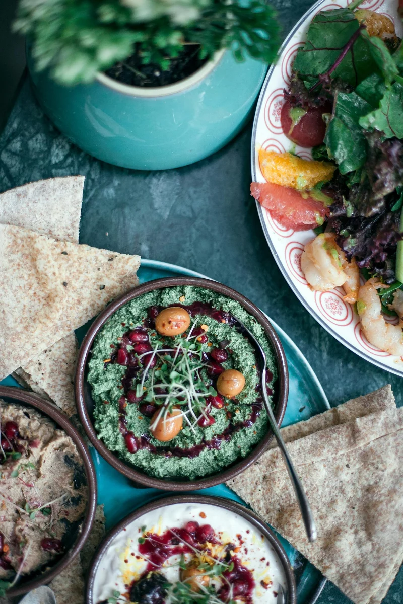 Delicious and colorful meal with hummus, salads, and flatbread for a healthy dining experience.