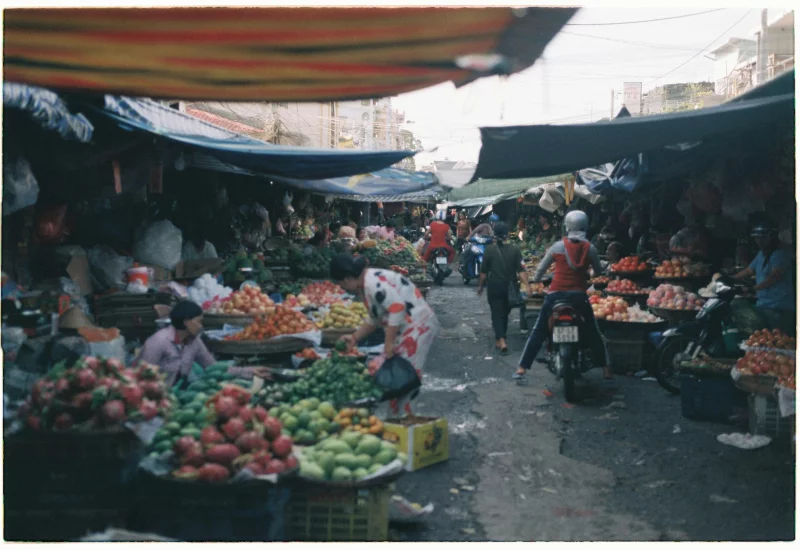 Bustling outdoor market scene with colorful produce and vendors.