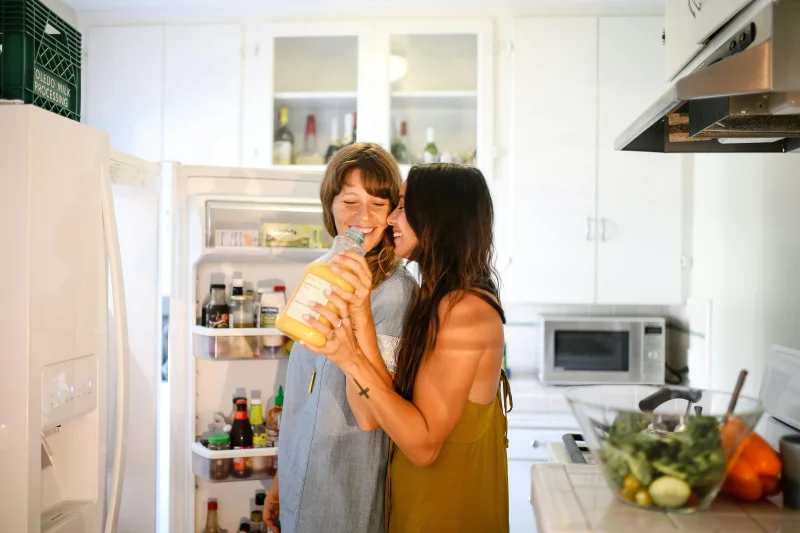 A smiling couple shares a joyful moment in a bright kitchen setting, enhancing their healthy relationship.