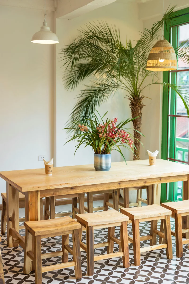 Bright and inviting restaurant interior featuring wooden furniture and lush plants, ideal for casual dining.