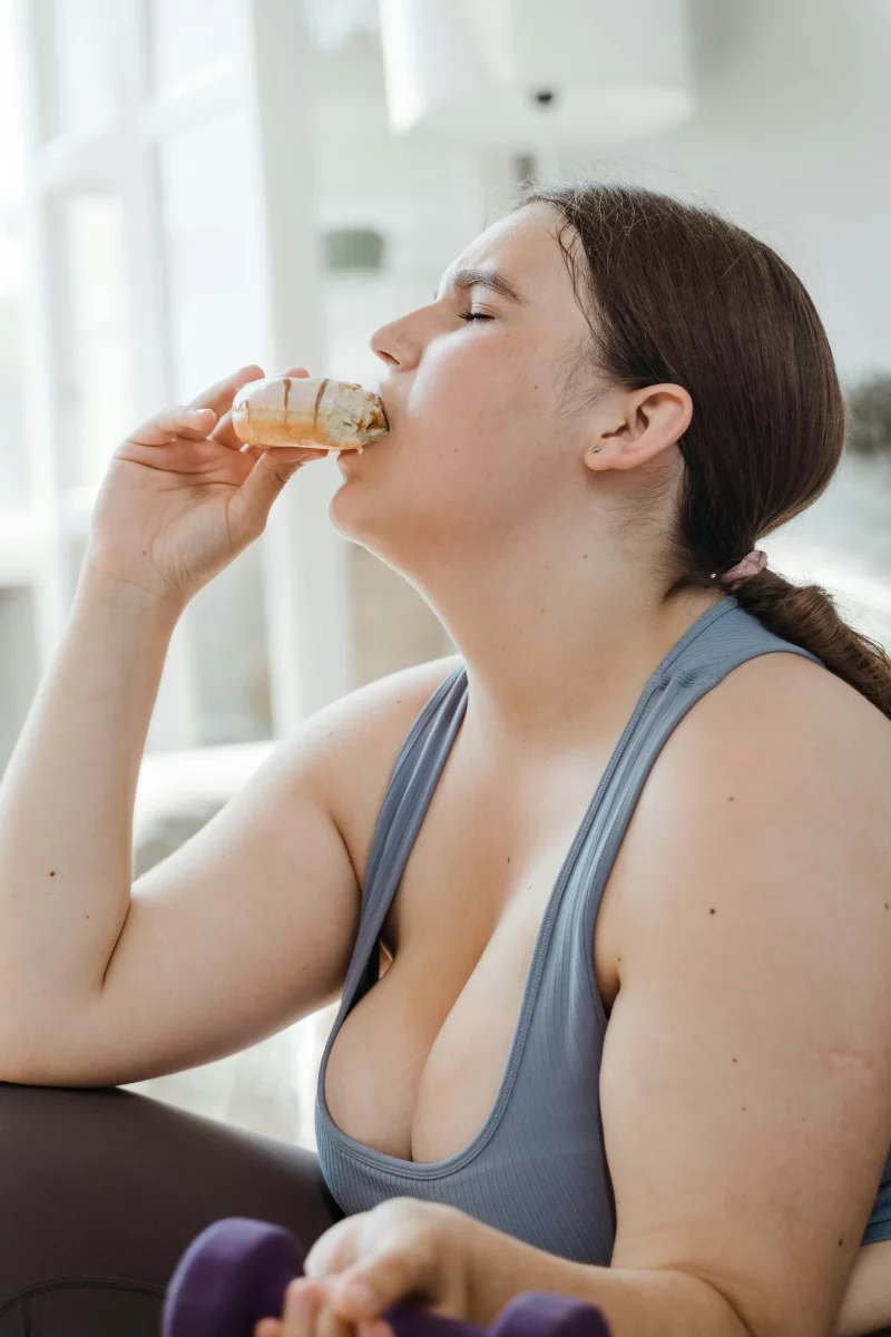 A woman in activewear takes a break with ice cream, highlighting balance in fitness and indulgence.