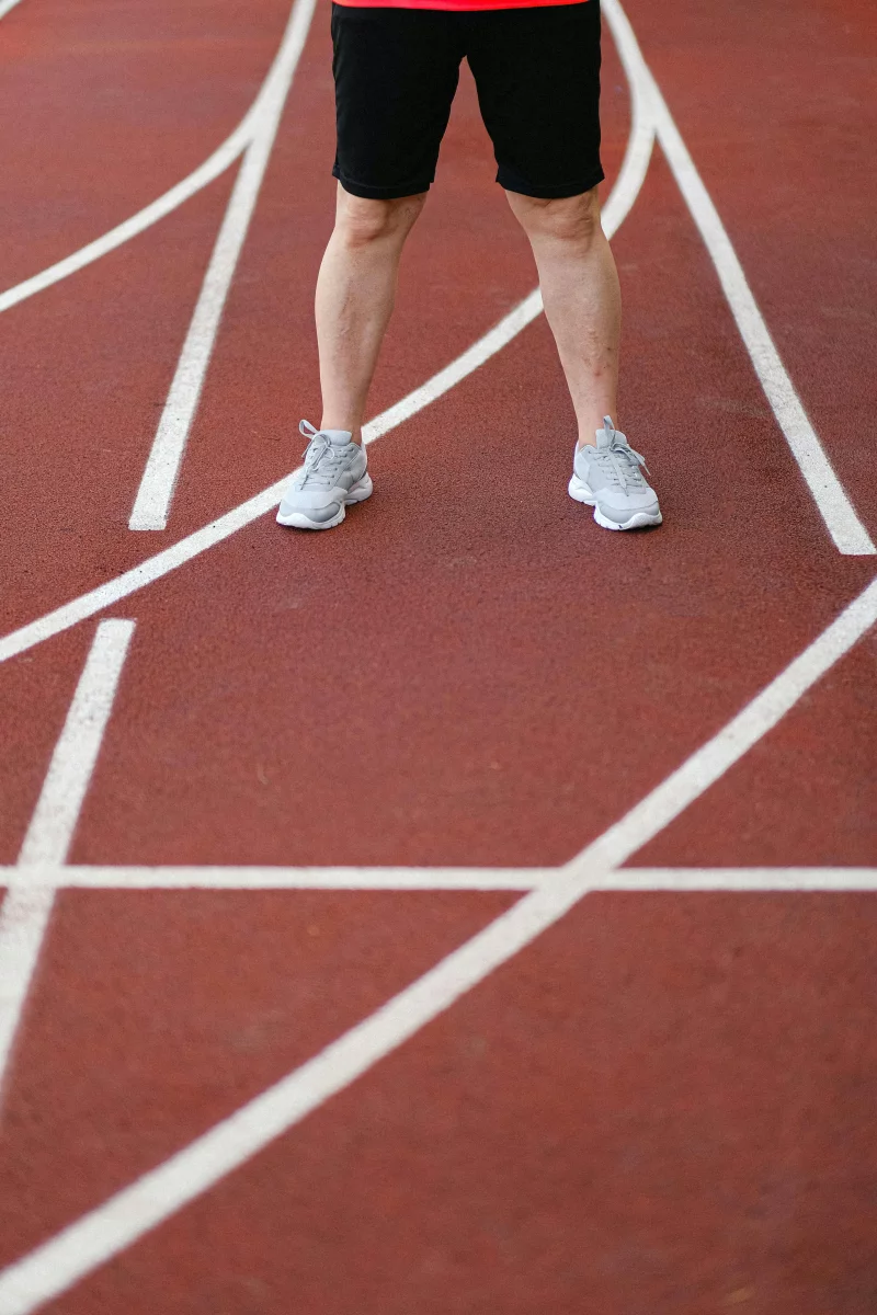 Athlete's legs at the start of a track, ready for a race.