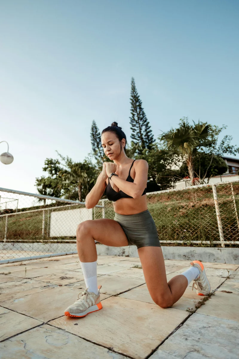 A woman performs a single-leg squat outdoors, embodying health and fitness.