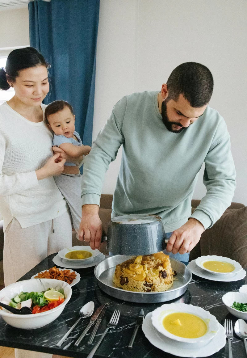 A family gathers around a table enjoying a homemade meal together.