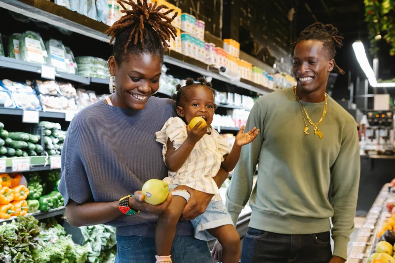 Happy family shopping together in a bright and lively supermarket, enjoying fresh produce.