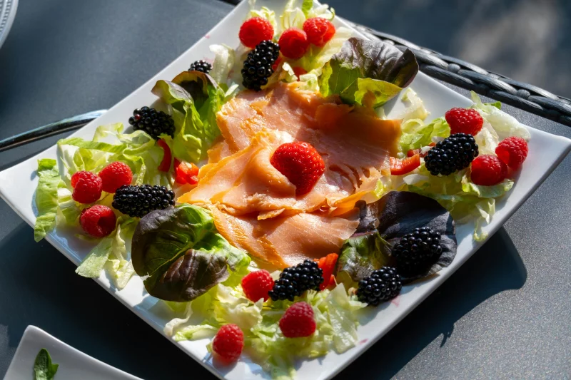 Delicious salmon and berry salad served on a plate, perfect for a healthy summer meal.