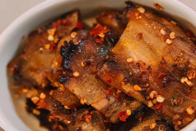 Close-up of a spicy Asian eggplant dish with chili flakes in a bowl.