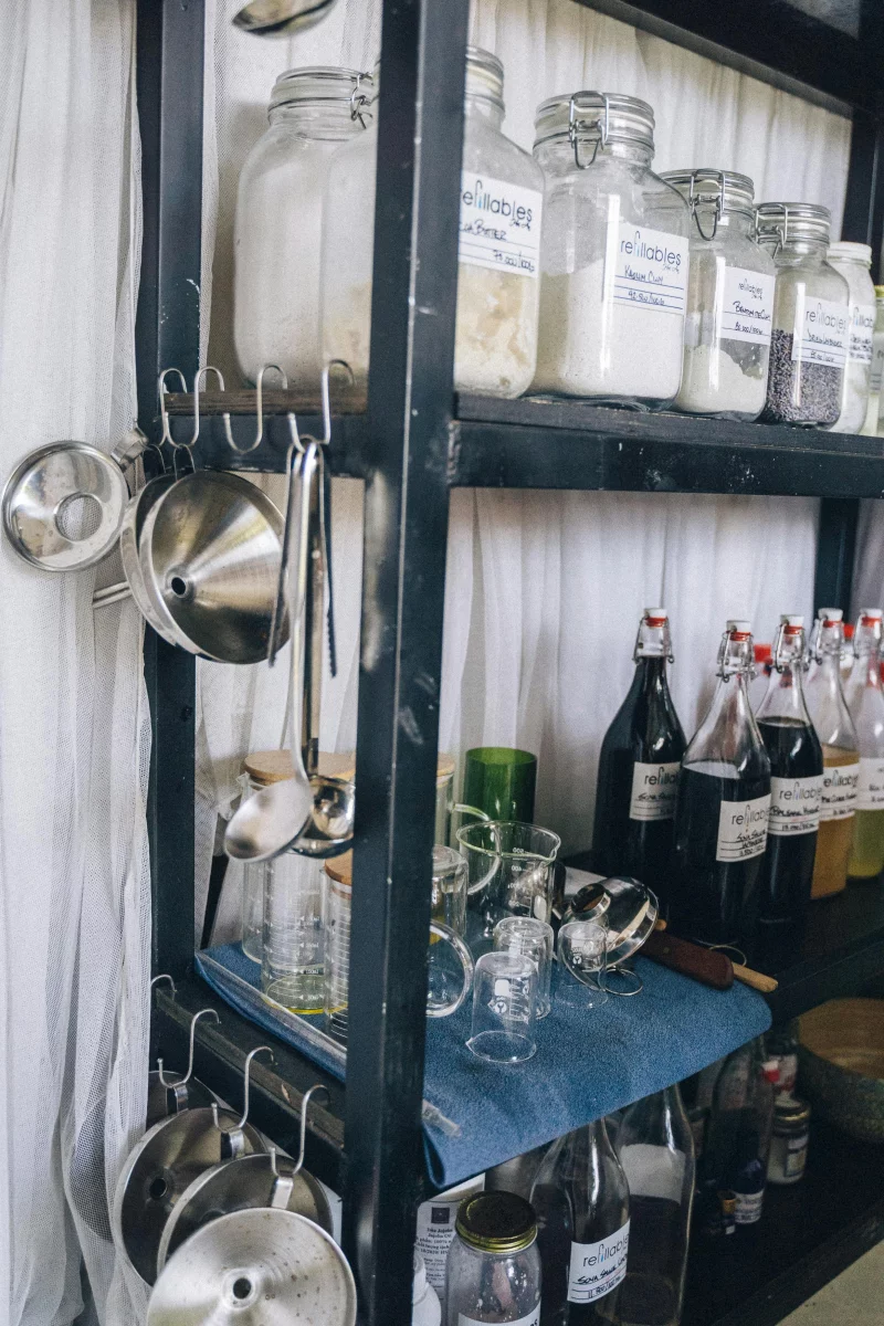 A pantry shelf organized with glass jars and bottles, perfect for home decor inspiration.