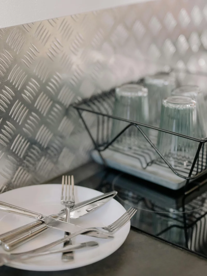Sleek kitchen setup with utensils and glasses on a drying rack.