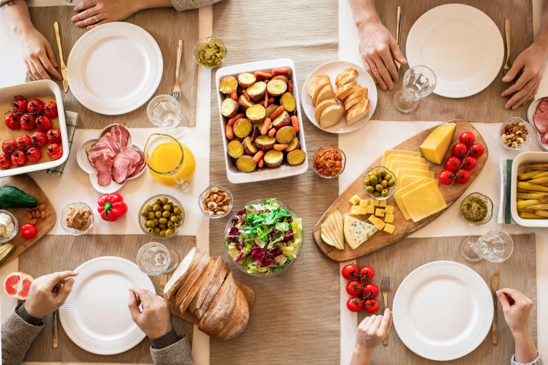 An overhead shot of a diverse, appetizing spread on a dining table ready for a meal.