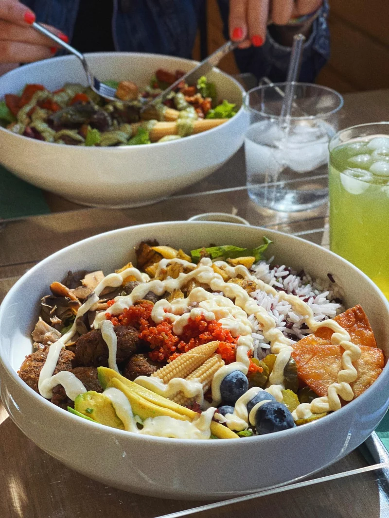 Top view of nutritious meal bowls with fresh vegetables, fruits, and meat, perfect for a healthy diet.