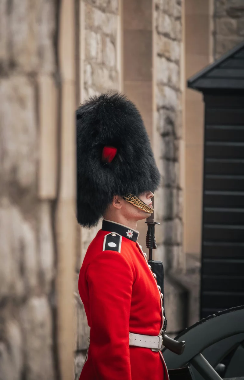 British royal guard in traditional red uniform and bearskin hat at Tower of London.