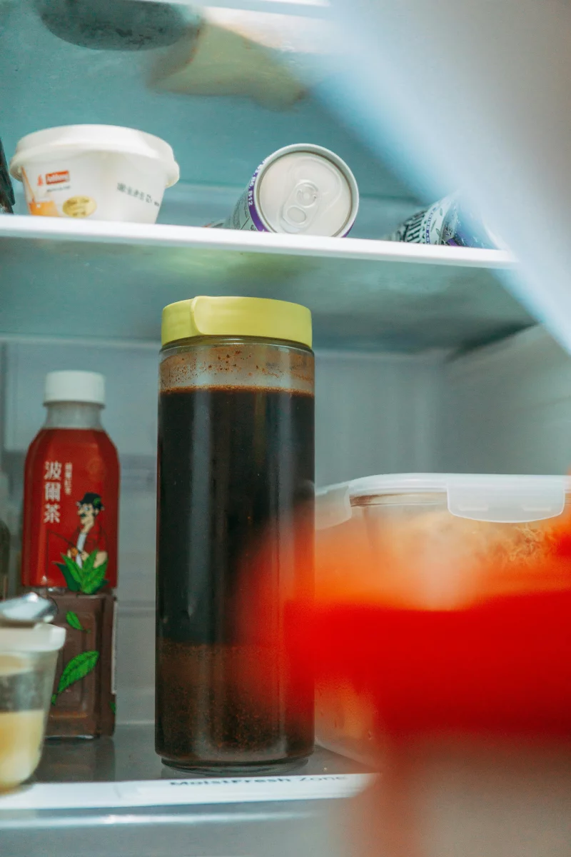 Close-up view of assorted food and drinks neatly arranged on refrigerator shelves for freshness.