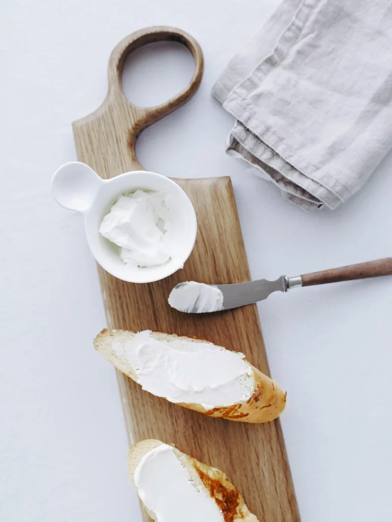 A simple flat lay of bread and cheese on a cutting board.