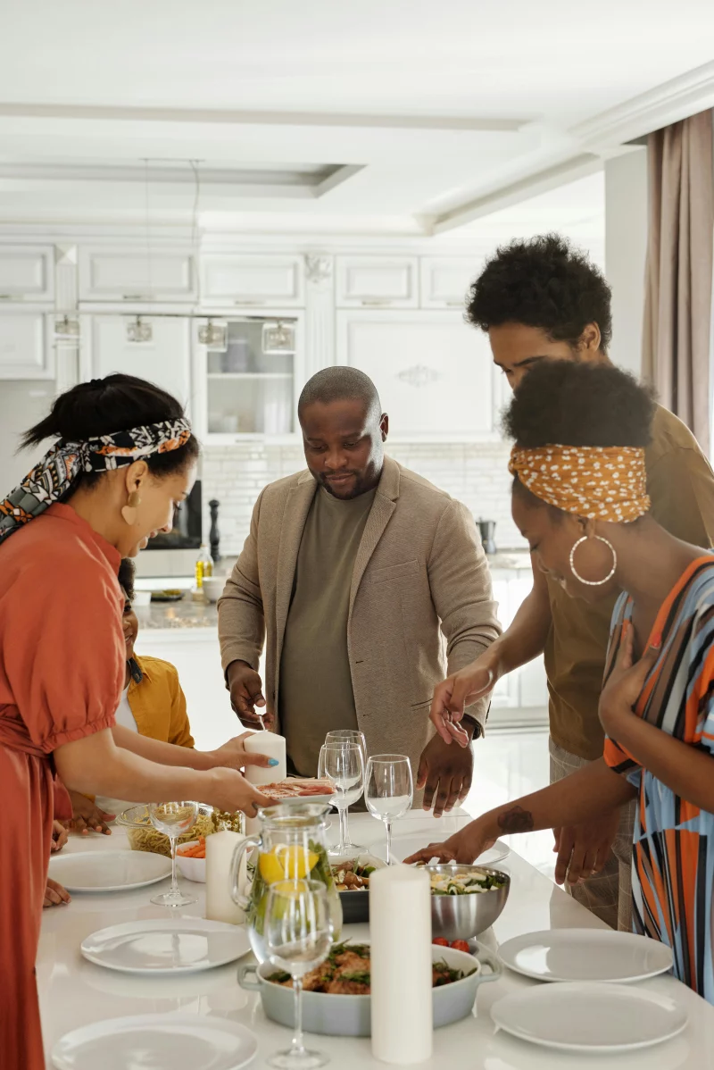 Diverse family celebrating at home, preparing a meal together in a warm atmosphere.