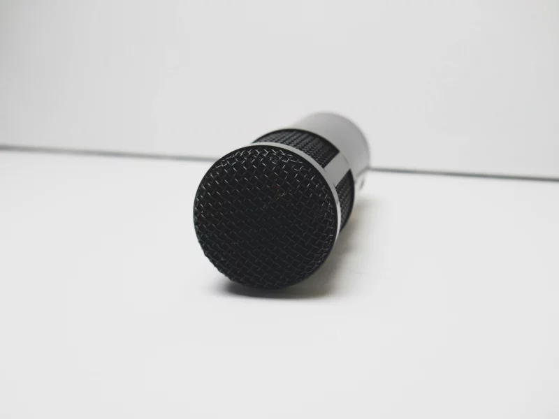 A detailed view of a microphone on a white background, perfect for music or broadcasting themes.