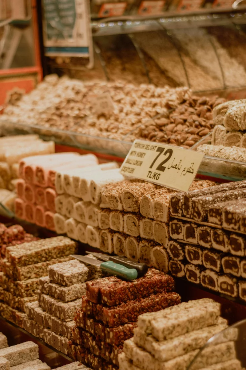 A delightful close-up of traditional Turkish sweets, including baklava and halvah, displayed in an outdoor market setting.