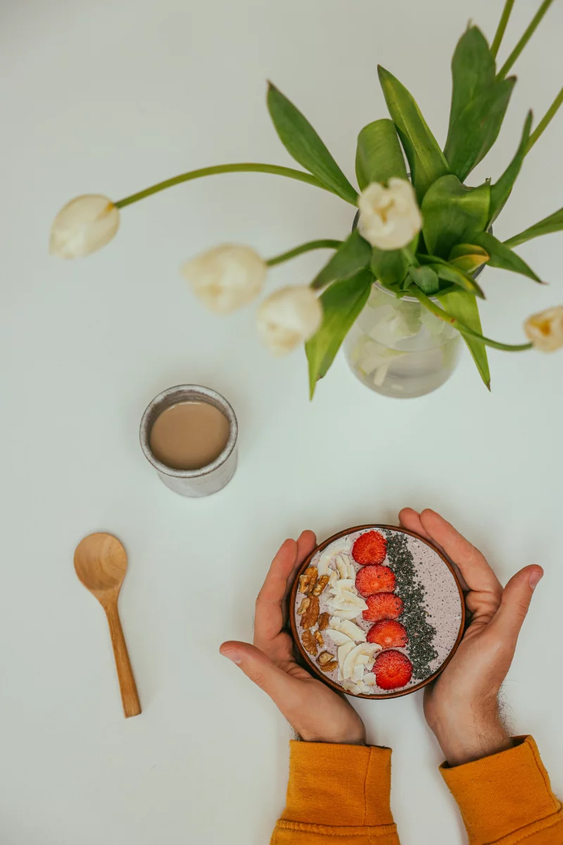 A vibrant breakfast bowl with strawberries, seeds, and a cup of coffee, perfect for a healthy start.
