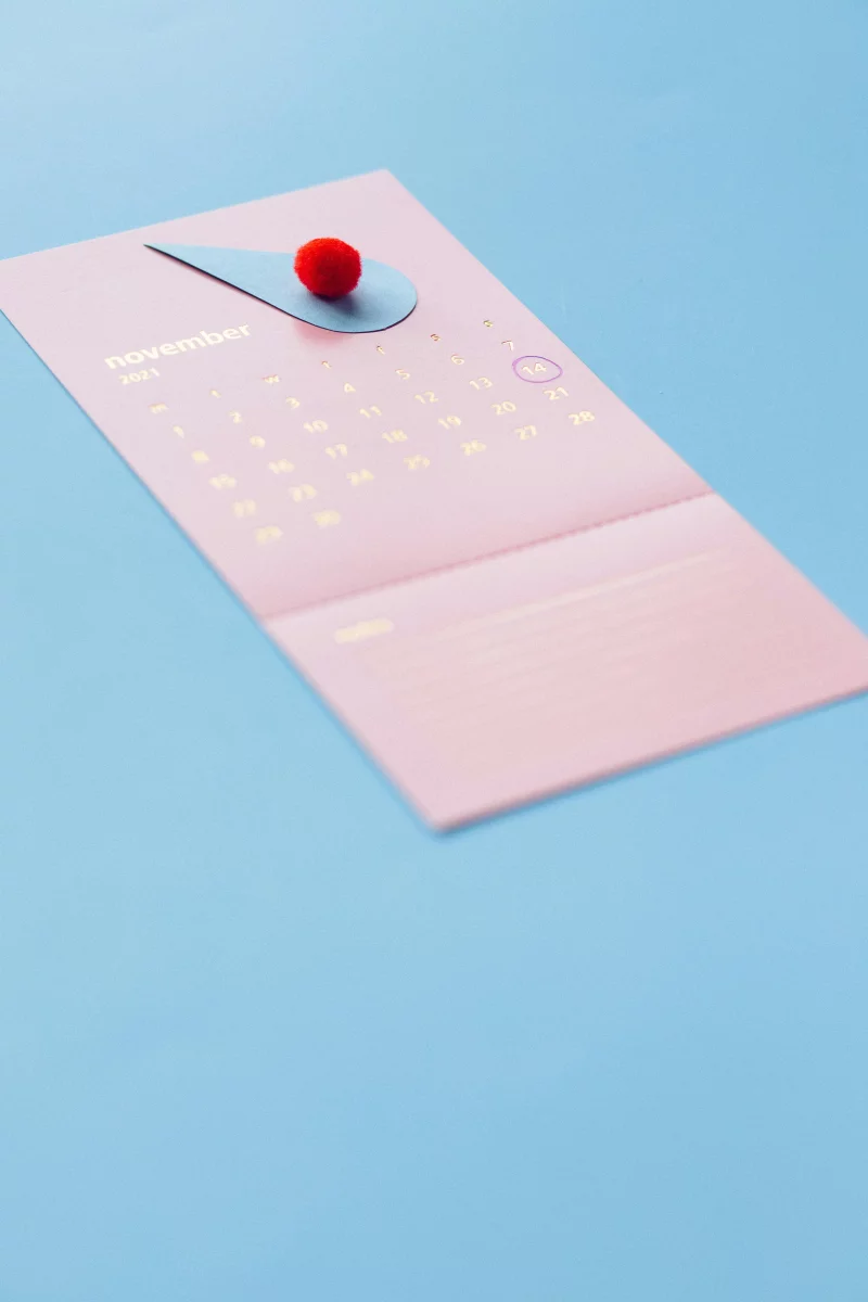 A simple November calendar page with a red ball placed artistically on a blue background, conveying modern elegance.