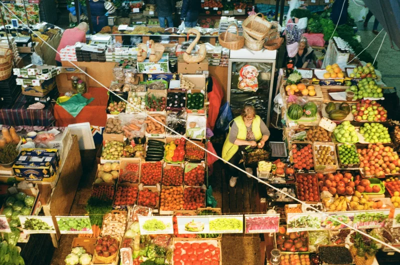 Aerial view of a bustling market in Kyiv with diverse fruits and vegetables on display.