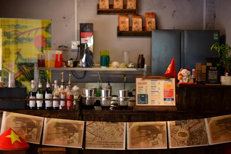 Coffee shop counter with drinks, decor, and a warm ambiance, showcasing Vietnamese cultural elements.