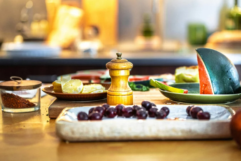 A vibrant scene featuring fruits, a cutting board, and spices in a domestic kitchen.