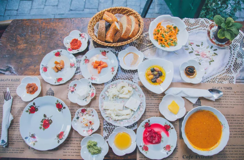 An inviting Turkish breakfast spread with diverse dishes on an outdoor wooden table.