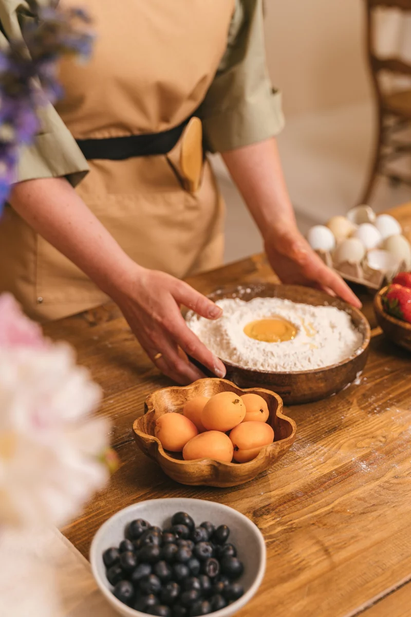 Hands preparing dough with fresh fruits and ingredients, capturing the essence of home baking.