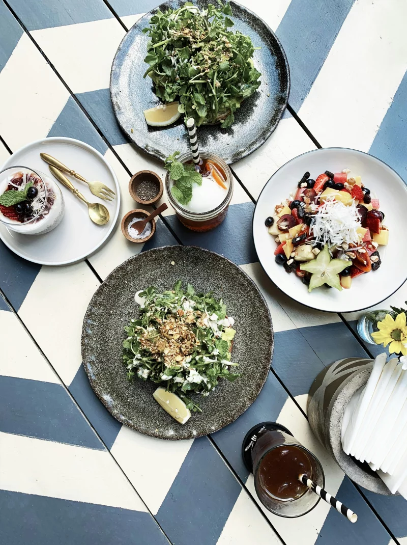 Fresh salads and drinks artfully arranged on a patterned table, ideal for lifestyle and food stock imagery.