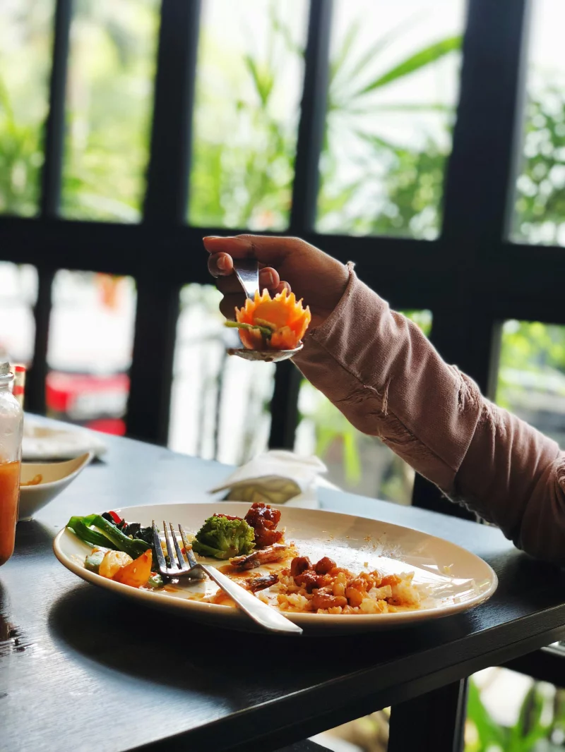 Close-up of a half-eaten dish in a relaxed dining setting, featuring fresh ingredients and vibrant colors.