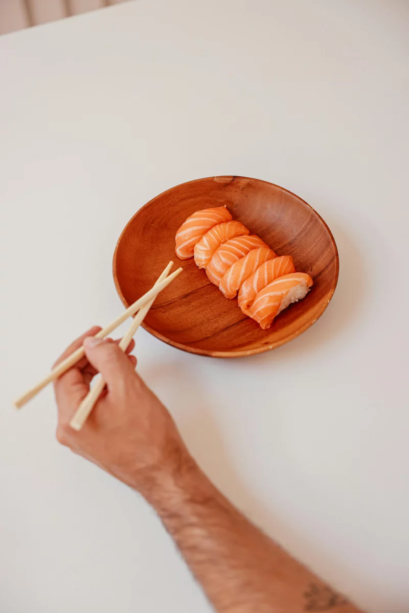 Salmon nigiri sushi with chopsticks, perfect for Japanese cuisine lovers.