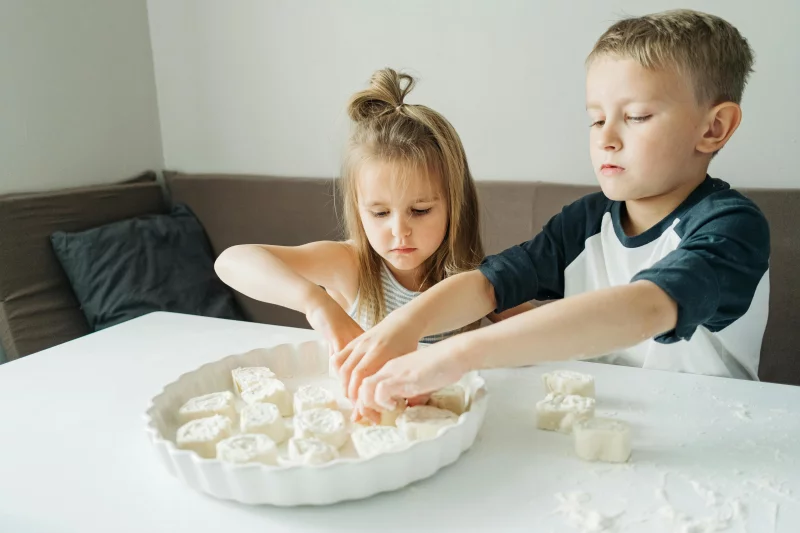 Children enjoying a fun bonding moment as they bake cookies at home.