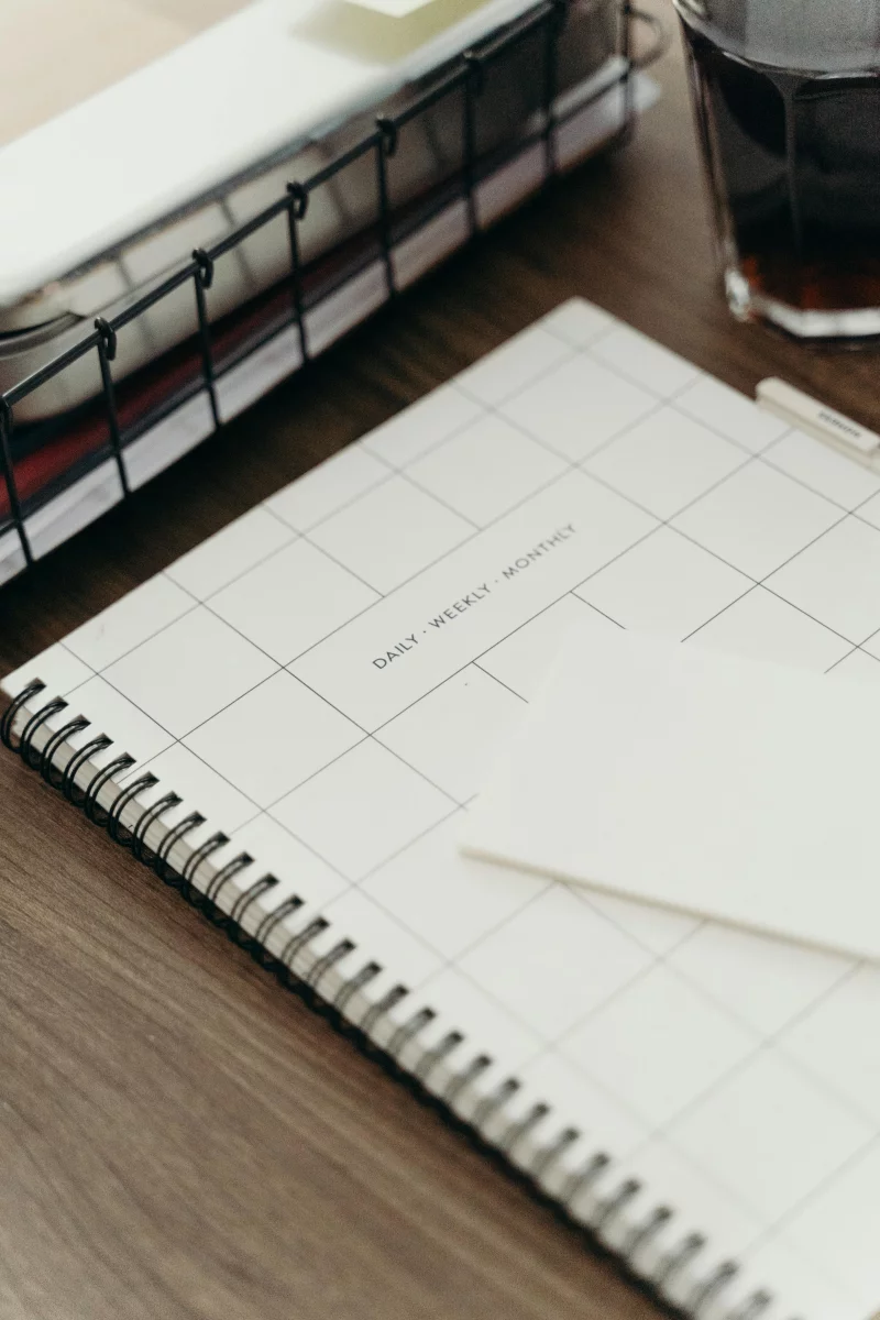 A minimalist desk setup featuring a planner, coffee, and tablet for productivity inspiration.