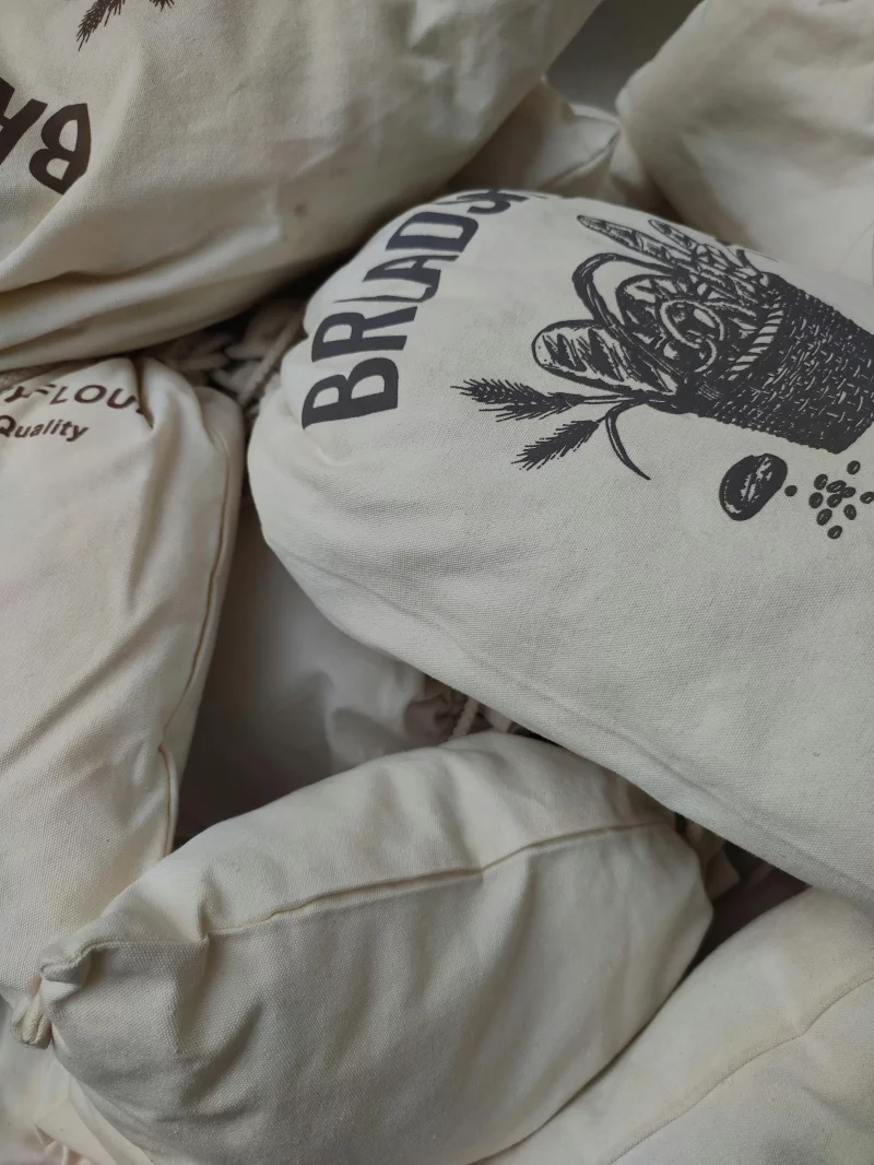 Close-up of vintage sacks with stenciled illustrations and text, highlighting rustic appeal.