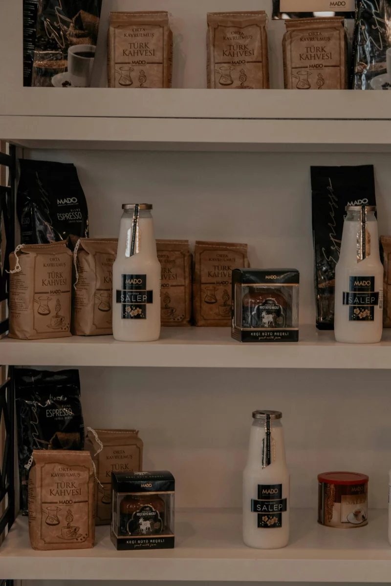Neatly arranged pantry shelves with glass bottles and coffee bags.