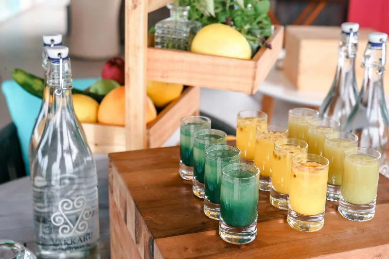 A vibrant display of fresh fruit juices and colorful fruits in a rustic setting.