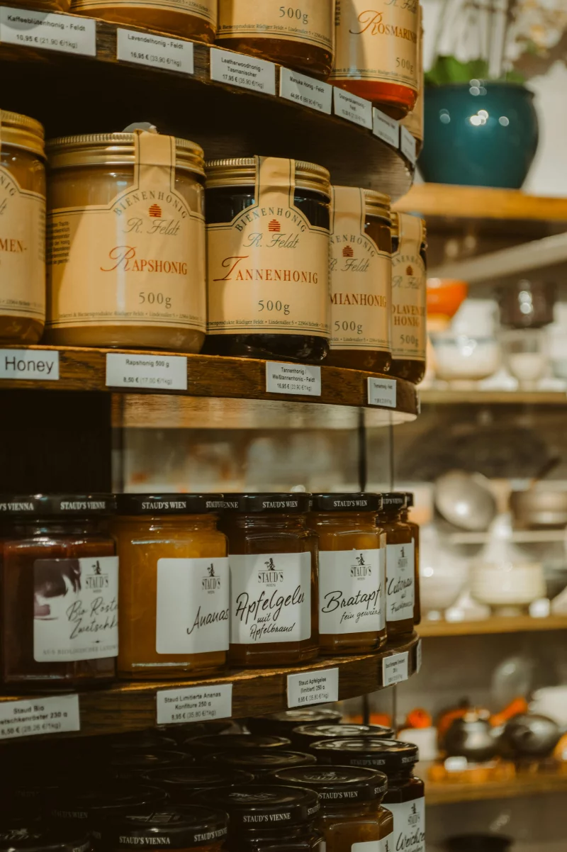 Close-up of honey jars on shelves in a Frankfurt store, showcasing various flavors and labels.