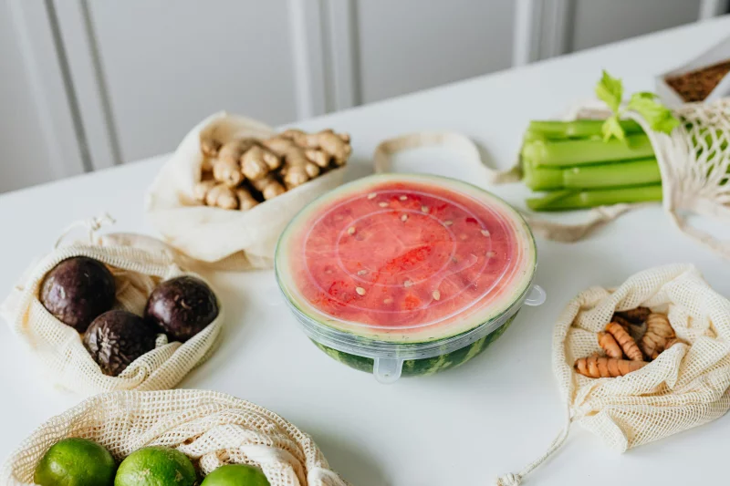 A high-angle view of fresh fruits and vegetables on a table featuring sliced watermelon.