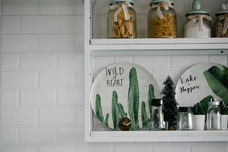 Chic kitchen shelf featuring decorative potted plants and labeled jars for a modern touch.