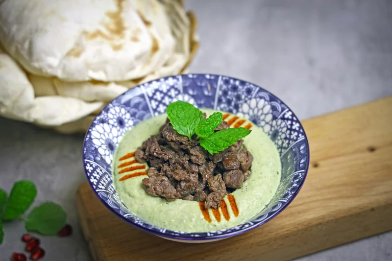 Delicious Middle Eastern lamb dish served with mint garnish in a traditional bowl.