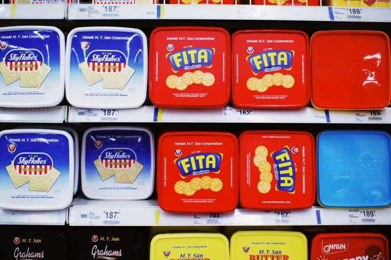Assorted cracker packages displayed on supermarket shelf, showcasing vibrant packaging designs.