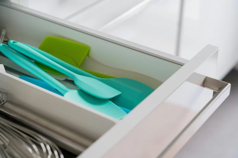 A tidy kitchen drawer featuring organized silicone spatulas and a whisk.
