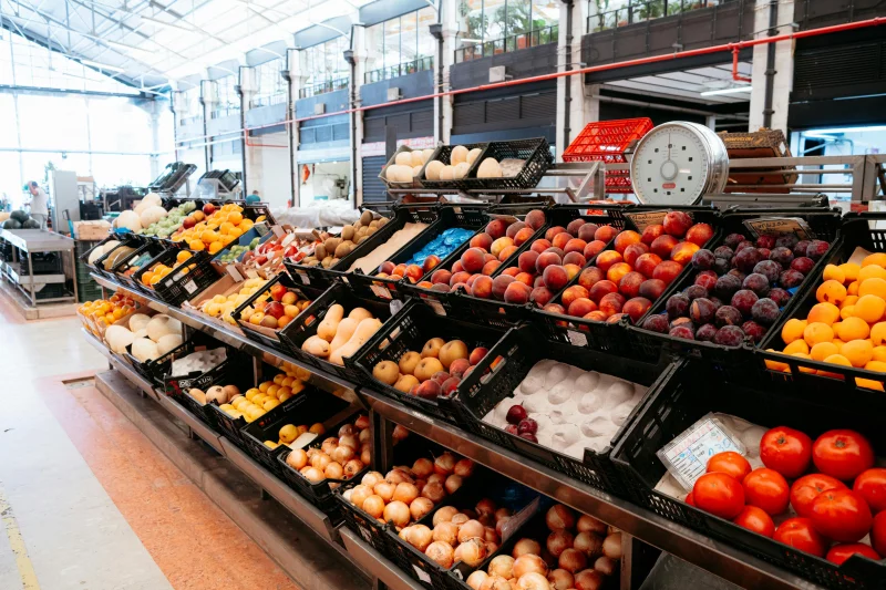 Colorful variety of fruits in a market stand showcasing freshness and abundance indoors.