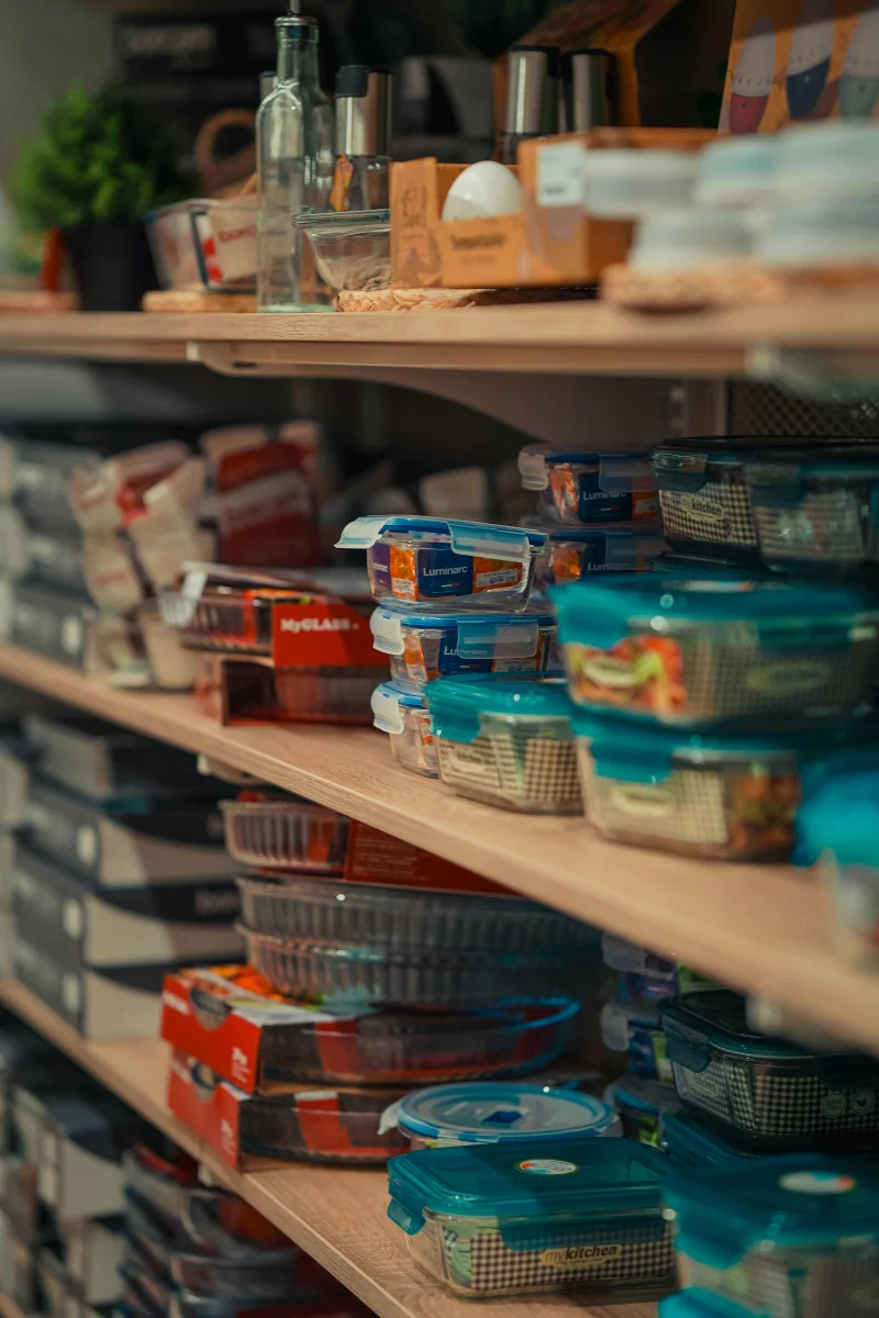 Neatly arranged storage containers on pantry shelves showcasing home organization.