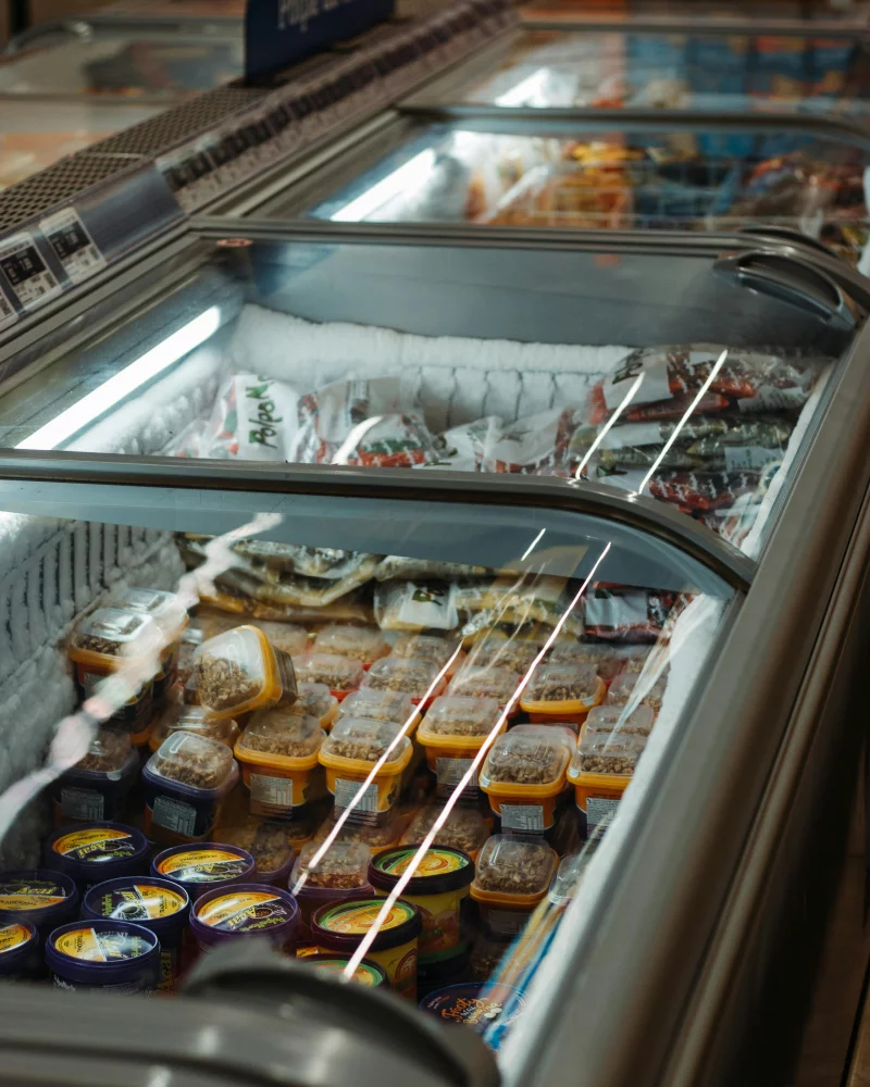A variety of packaged ice creams in a store freezer on display.